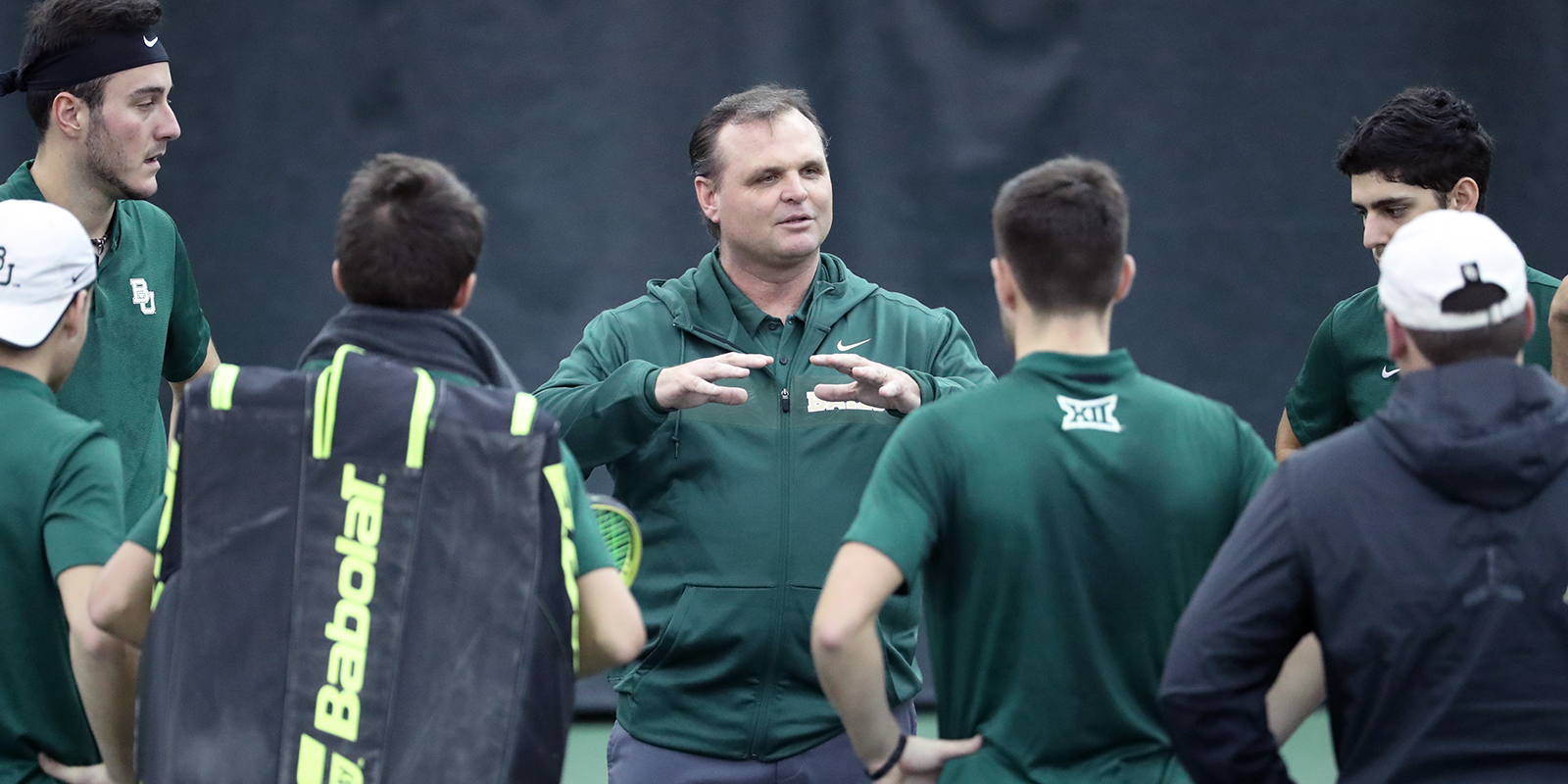 Head coach Brian Boland talks to the Baylor men's tennis team