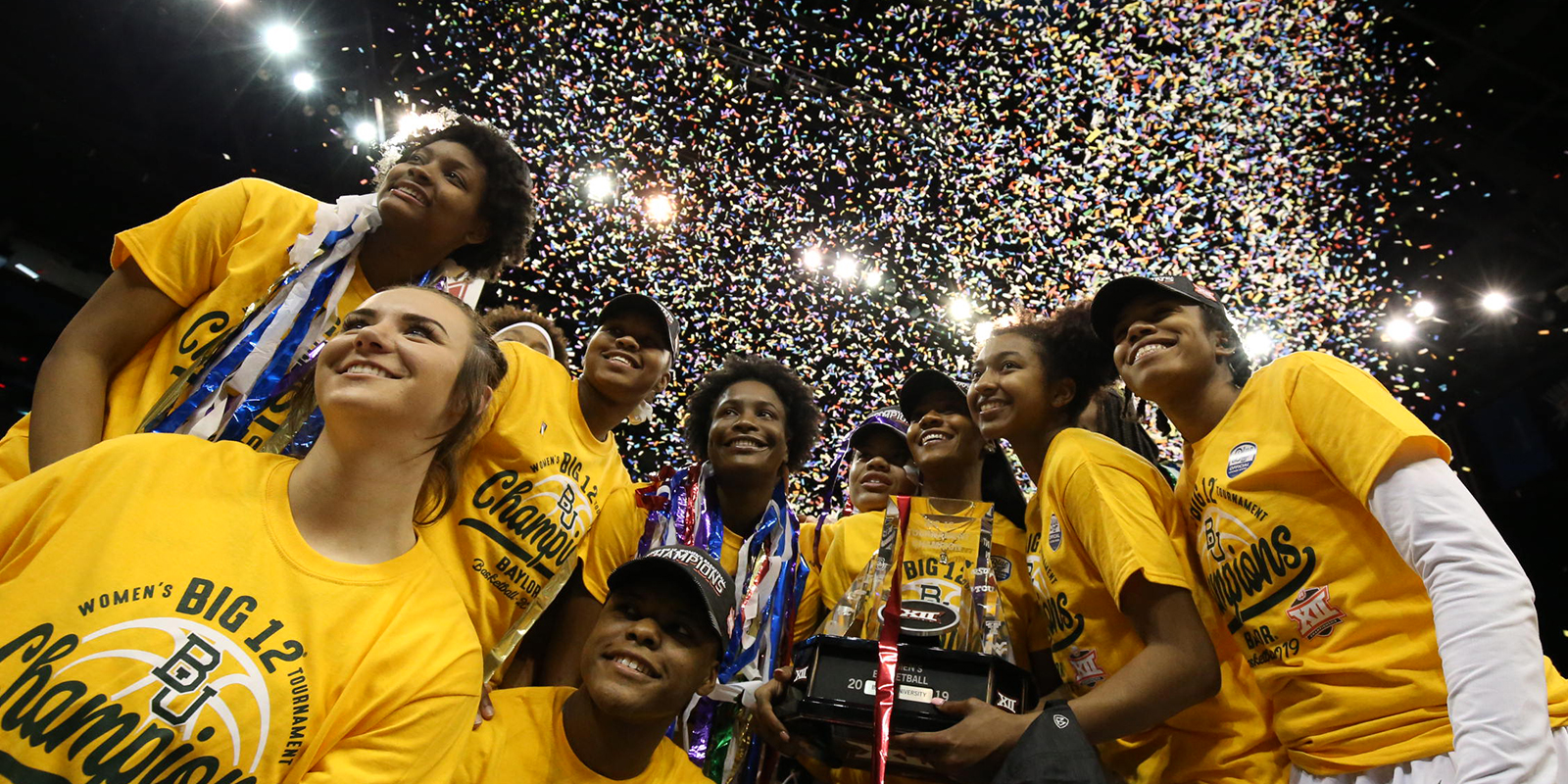 Baylor Lady Bears pose with the trophy as confetti falls
