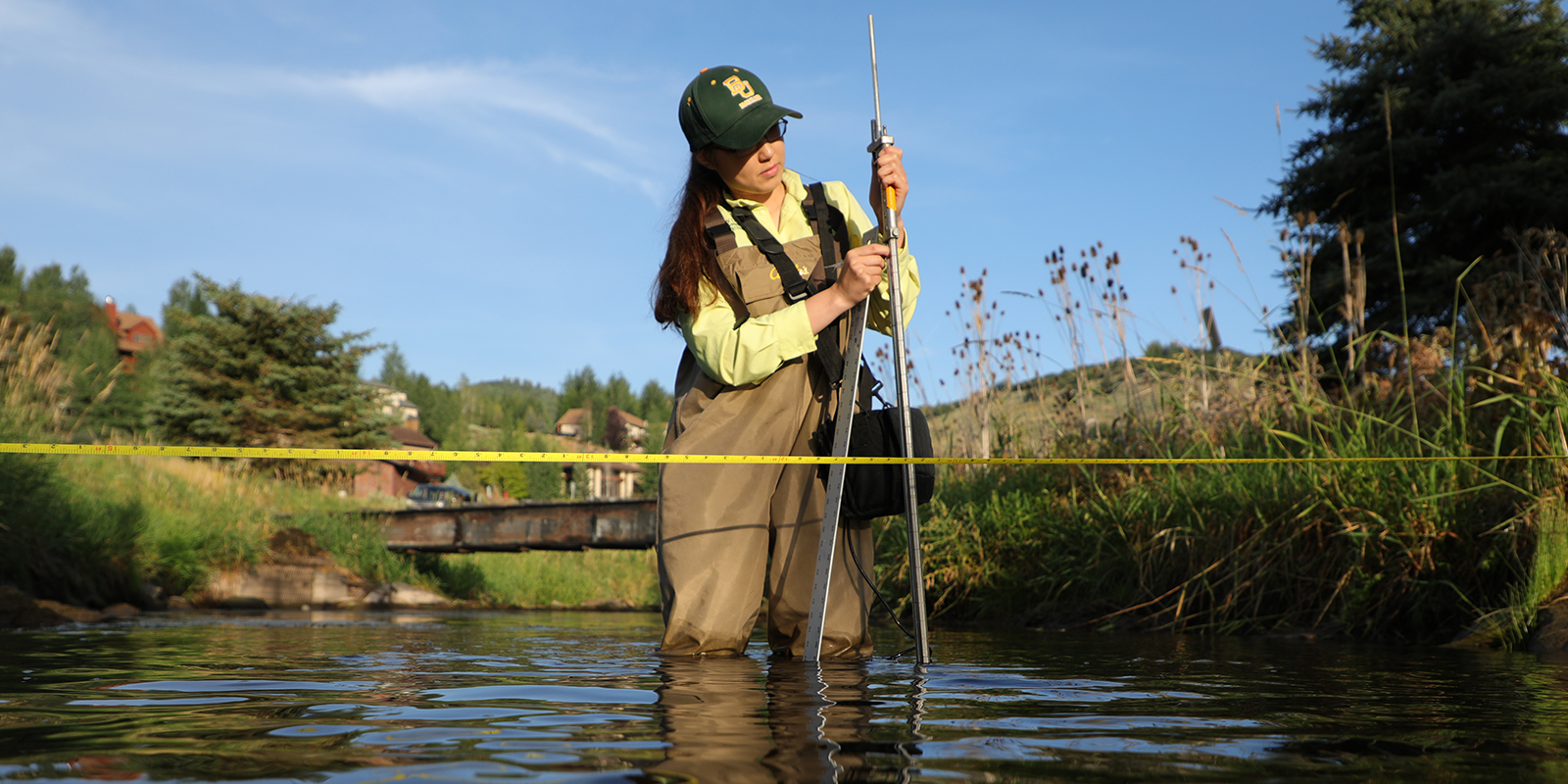 A Baylor research conducts water research in a stream