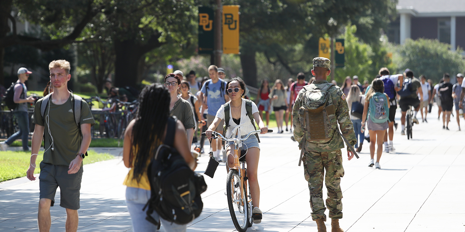 Students walk and ride down 5th Street on Baylor's campus