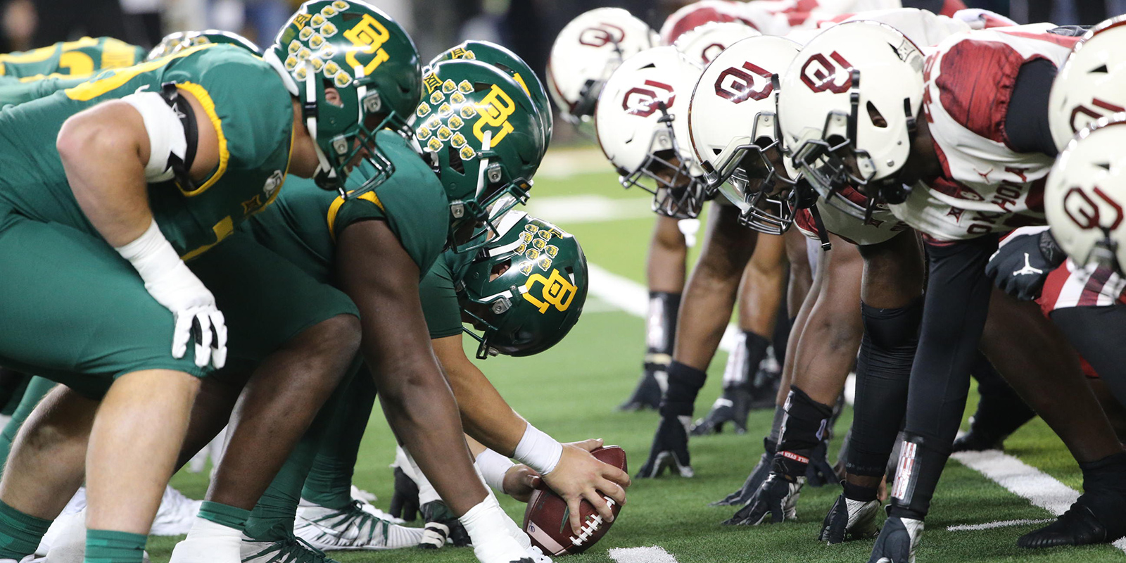 Baylor and Oklahoma football players lined up for the snap