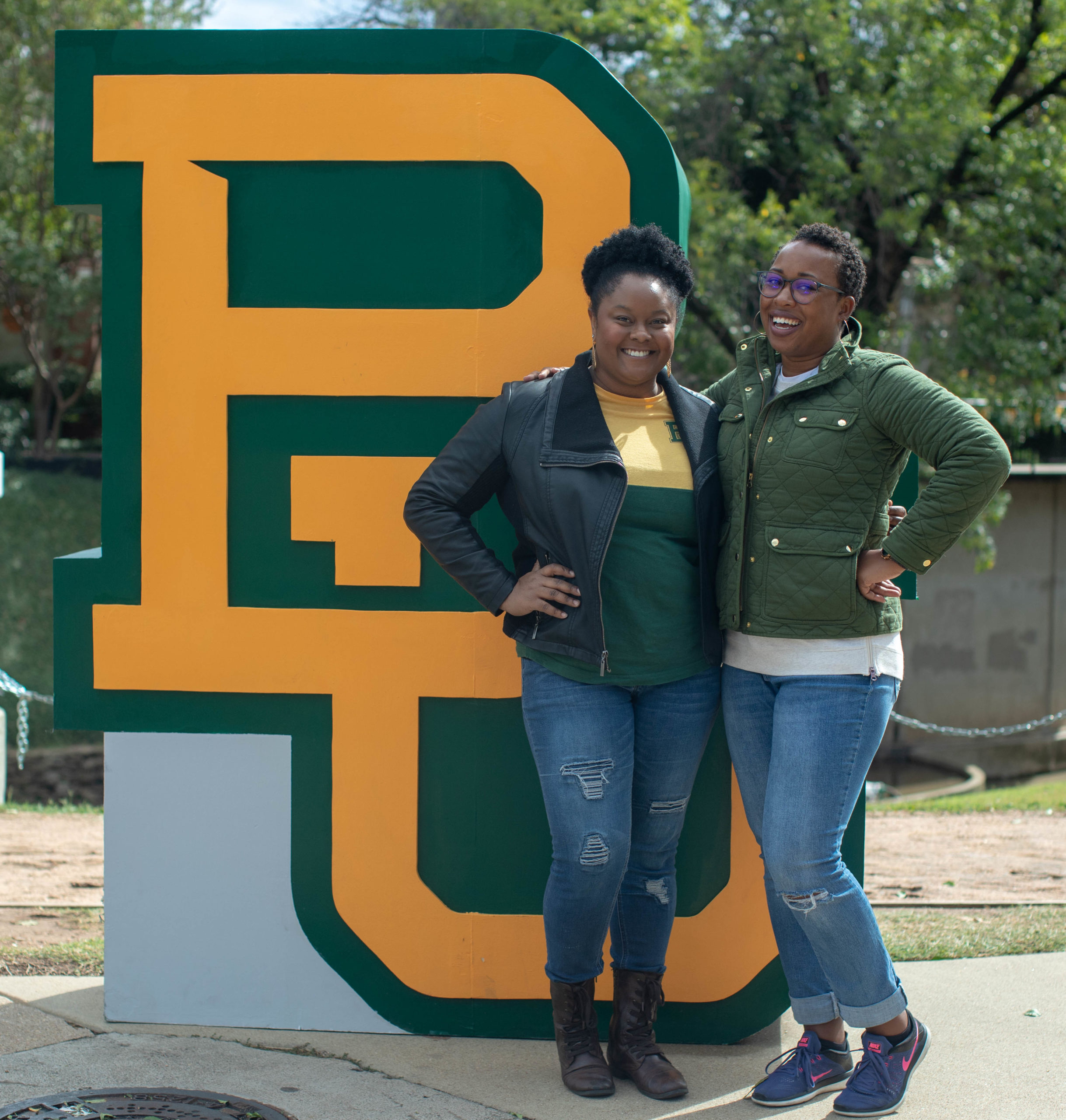 Cene Griffin and Maria Gaston, posing with the interlocking BU sign on campus