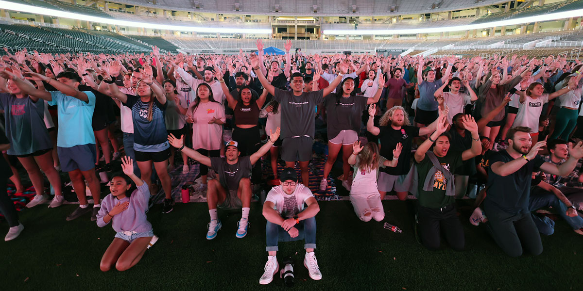 Students worshipping at McLane Stadium as part of FM72