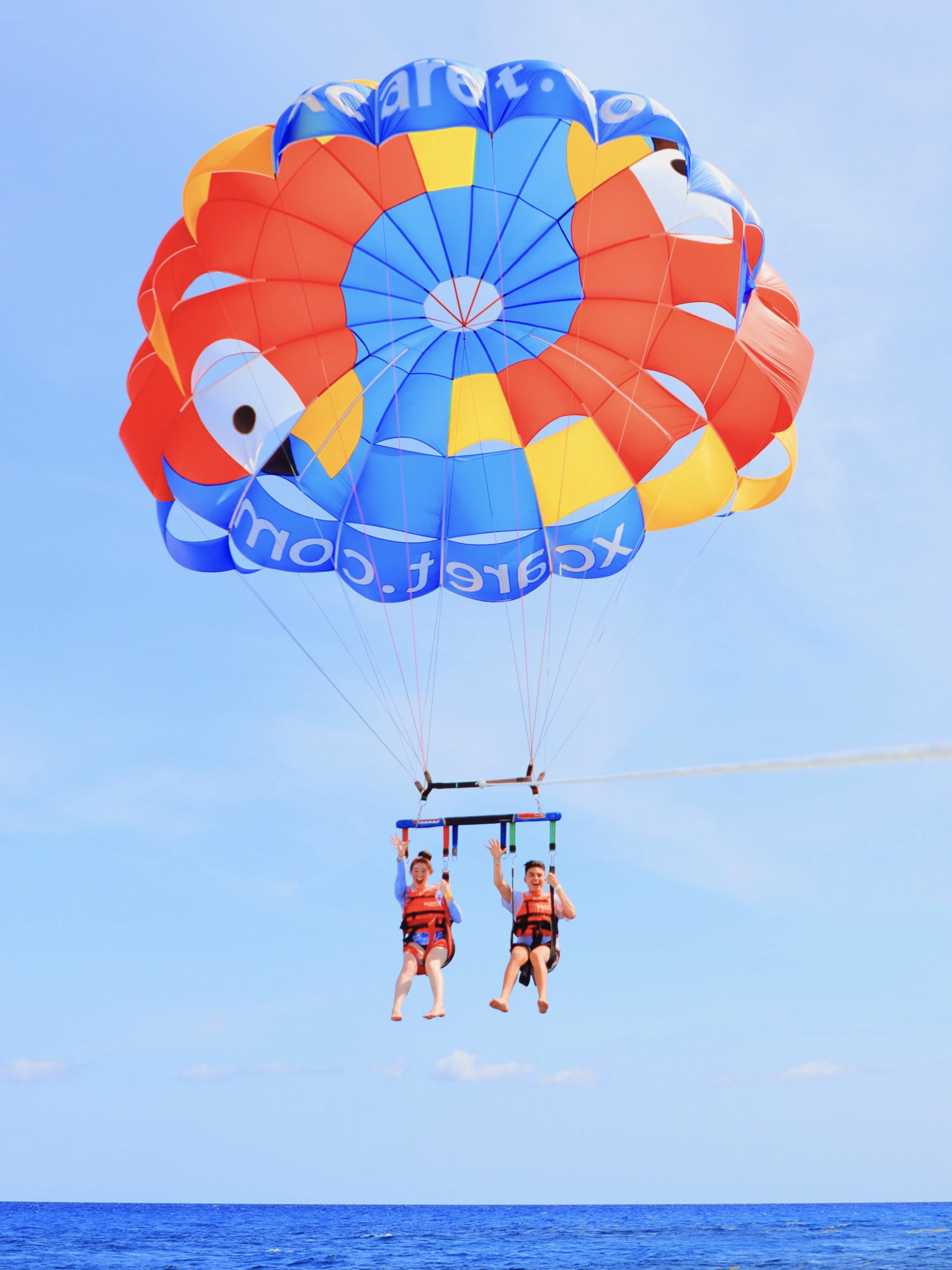 Two students doing "sic 'ems" while parasailing
