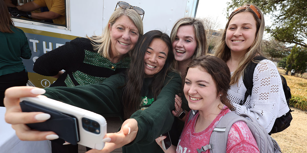 Students smiling for a selfie with President Livingstone