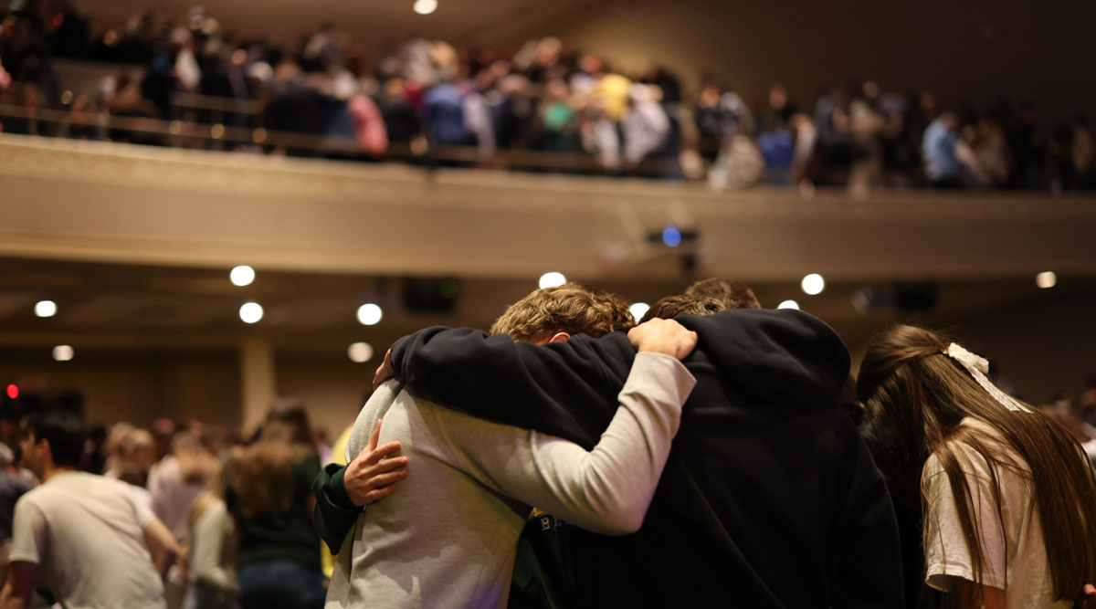 Baylor students praying together in Waco Hall