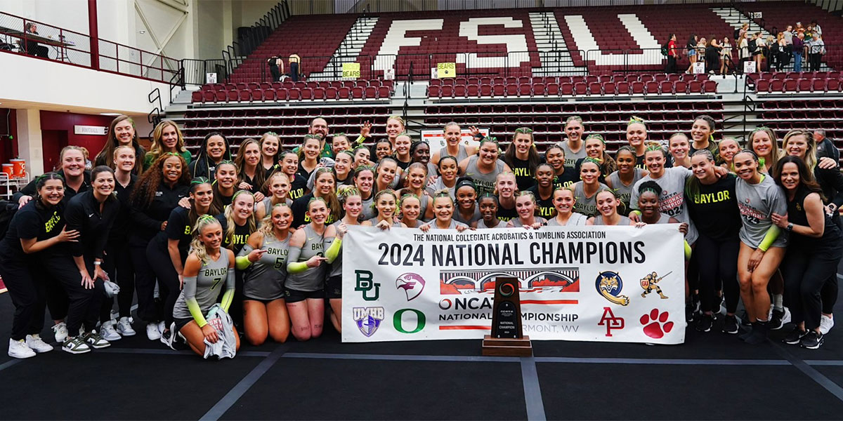 Baylor Acrobatics & Tumbling poses with the national champions banner and trophy