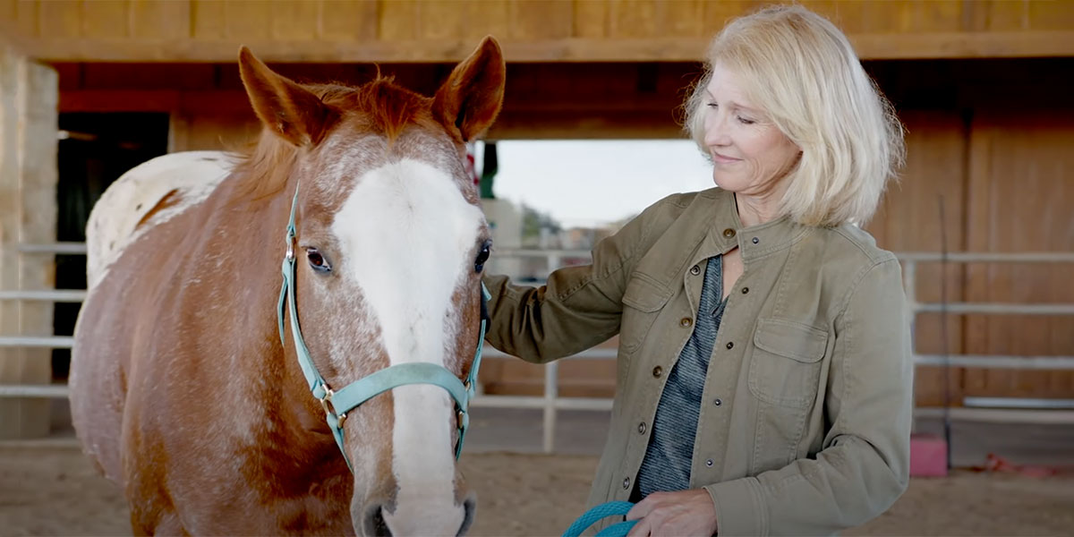 Dr. Beth Lanning standing next to a horse