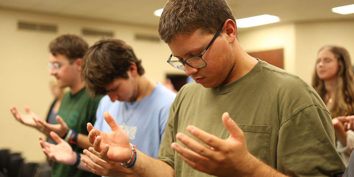 Students bow their heads in prayer