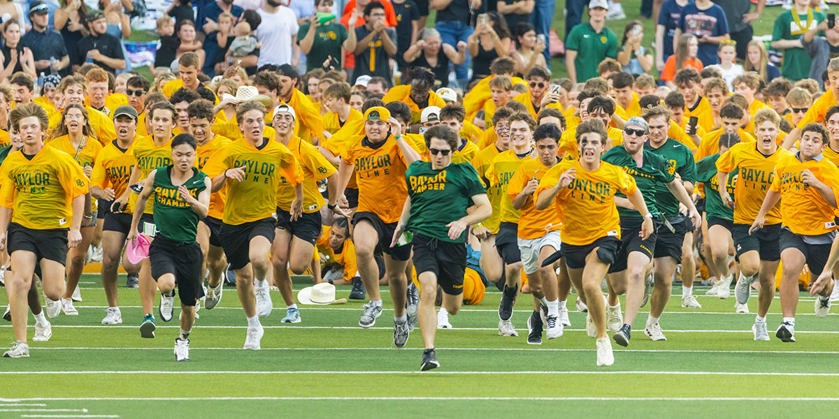 Baylor Line students running on the McLane Stadium field