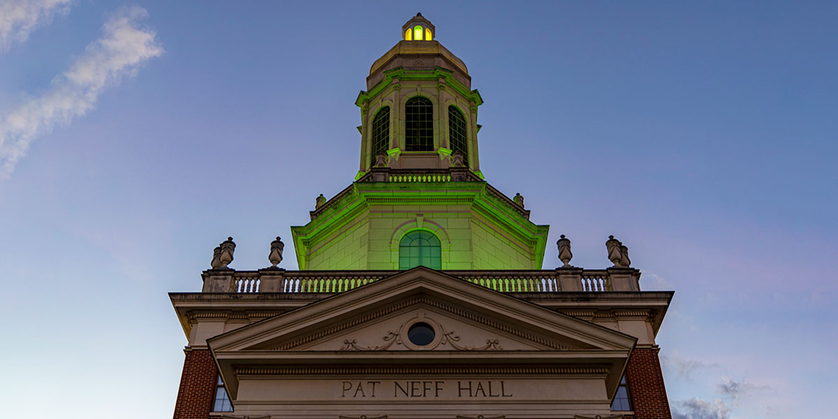 Pat Neff Hall lit green at dusk