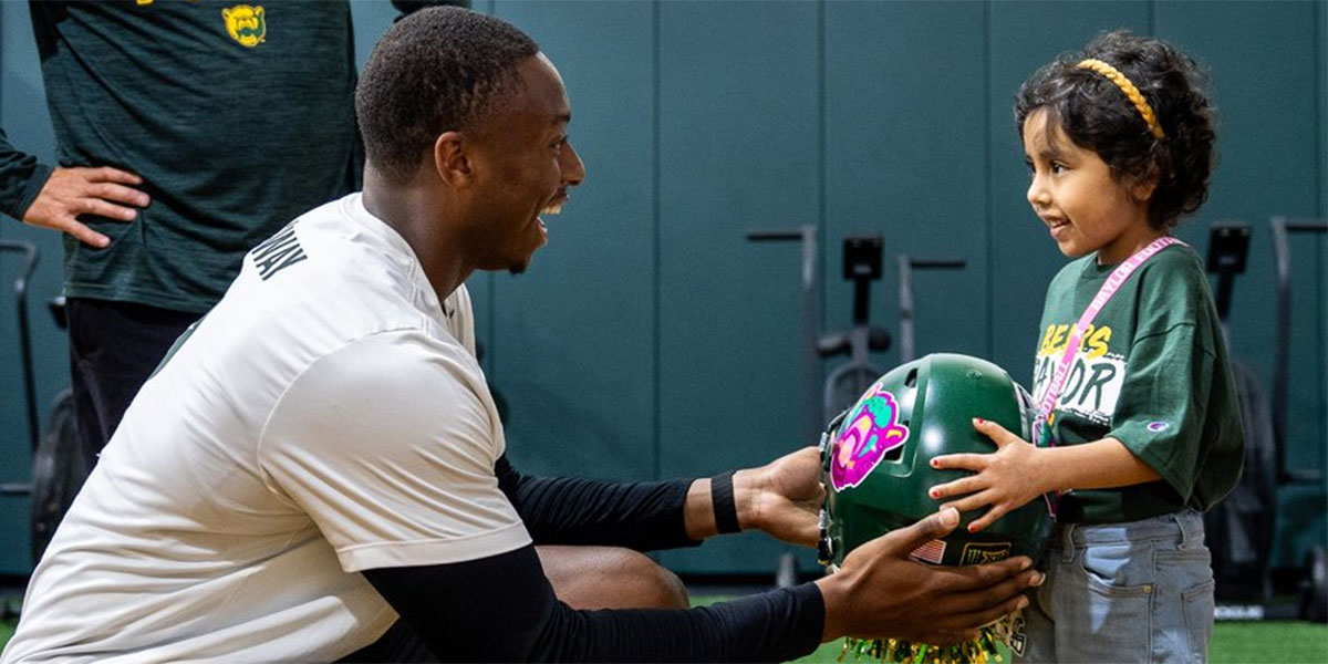 Baylor quarterback DJ Lagway presents the 'Helmet of Hope" to ILaria Ramirez